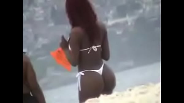 Mulata en tanga blanca en la playa.